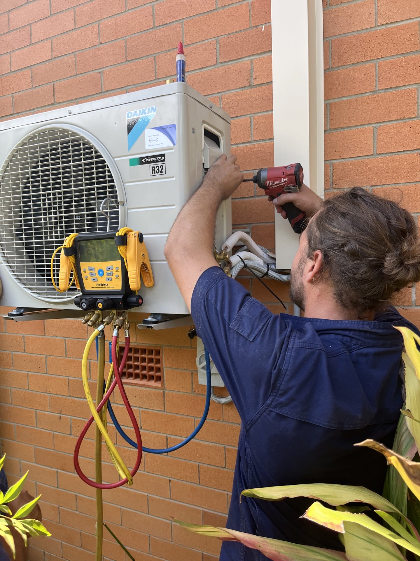 Licensed technicians performing a ducted aircon installation in a Logan home